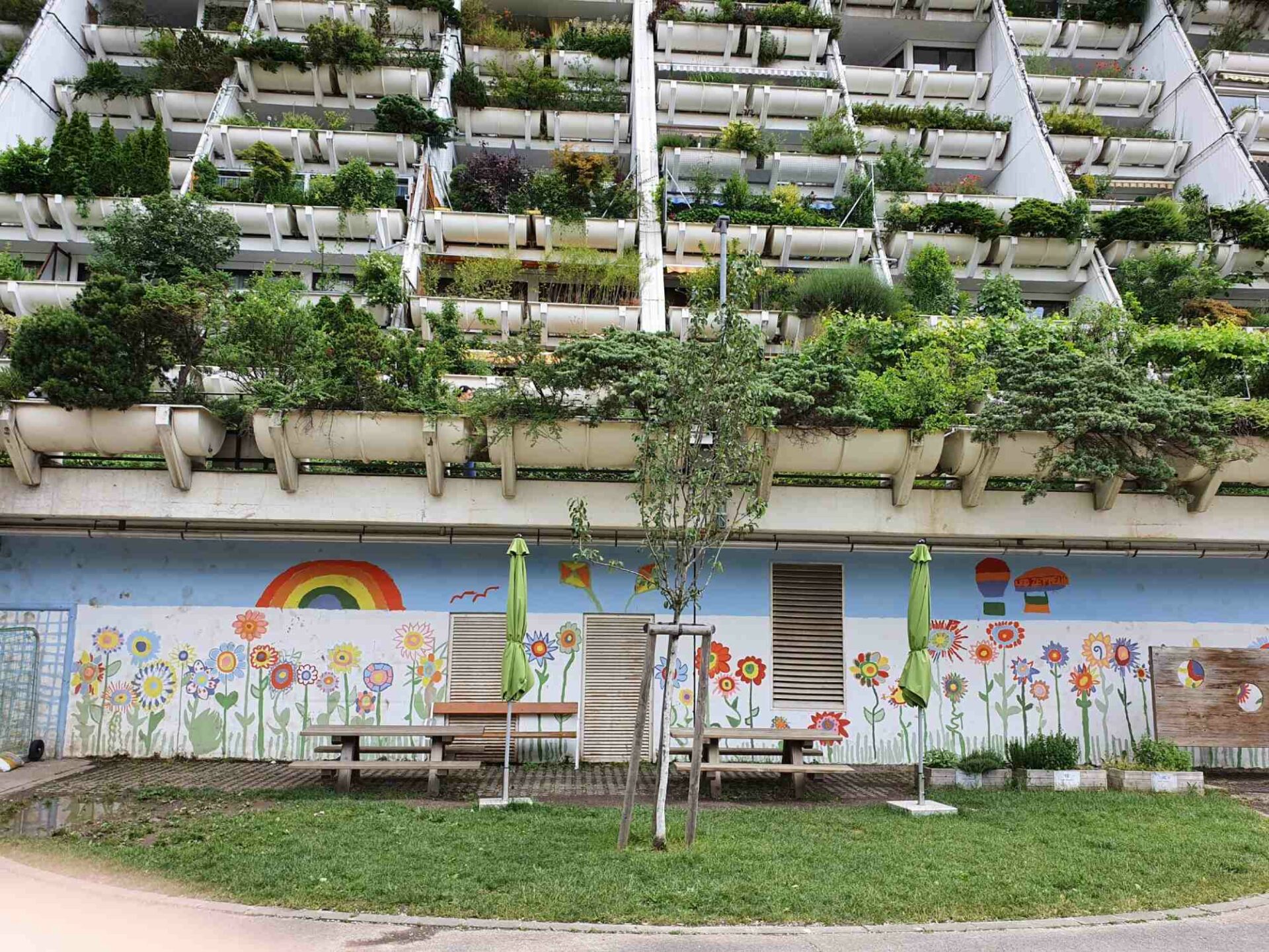 Im Hof der Grundschule von Alterlaa gibt es eine bunte Wand mit Blumenmotive und Regenbogen.